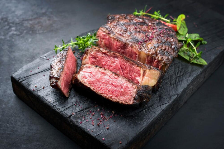 A barbequed Wagyu steak on a black cutting board