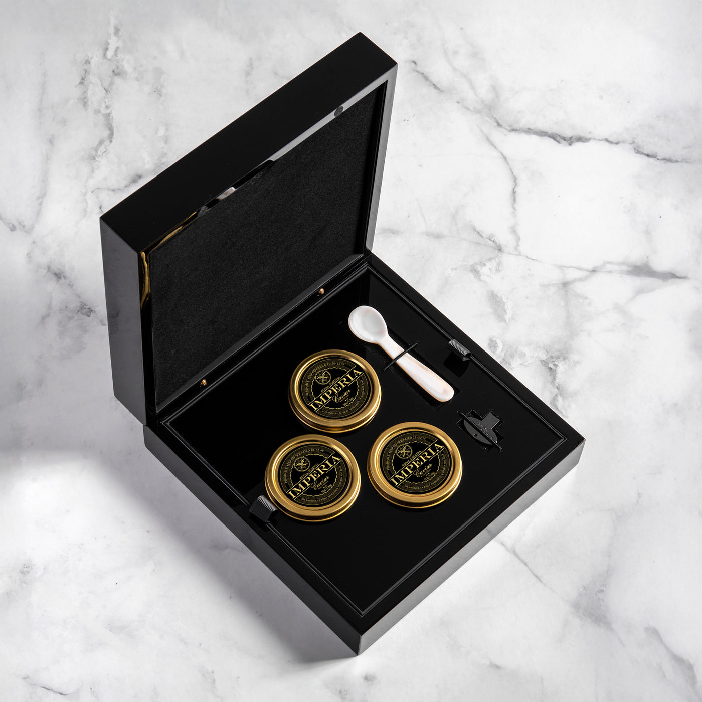 Imperia caviar served with blinis, chips, eggs, champagne, and mother-of-pearl spoon