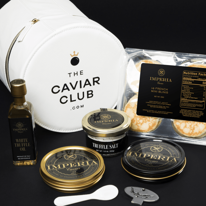 Caviar Club gift set with two Imperia tins, truffle salt, white truffle oil, French blinis, pearl spoon, and leather pouch.