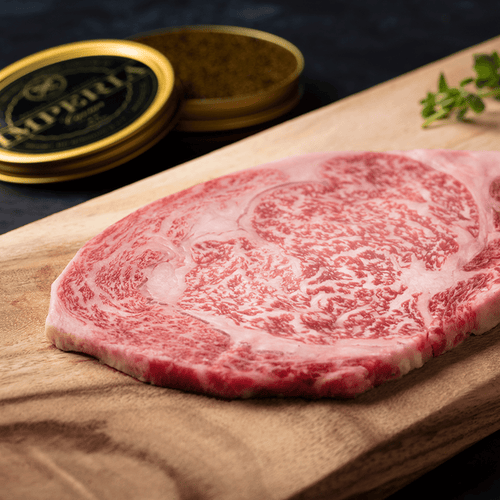 Raw A5 Wagyu ribeye steak with dense snowflake marbling on a wooden board with fresh oregano and peppercorns.